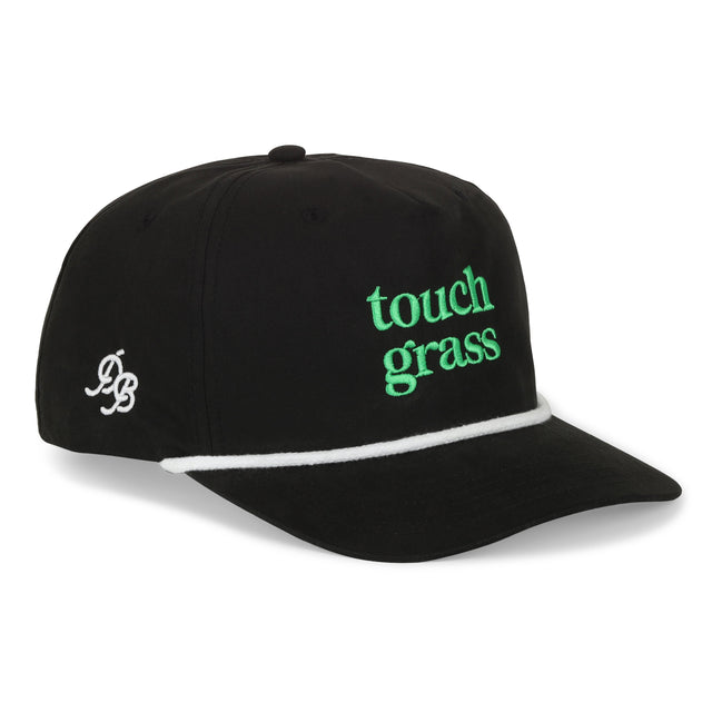 Black golf cap with green text 'touch grass' on a white background